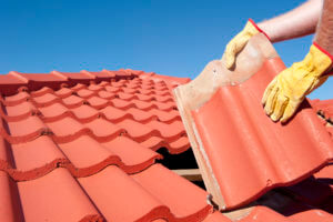 Someone repairing a concrete tile roof